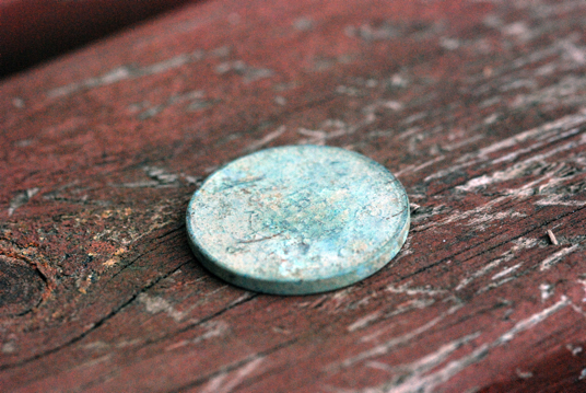 rusty penny on a wooden shelf