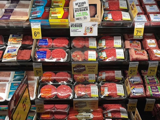 photo of meat case featuring fresh plant-based and conventional meat packages