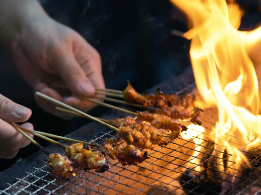 Cultivated meat being cooked over an open flame.