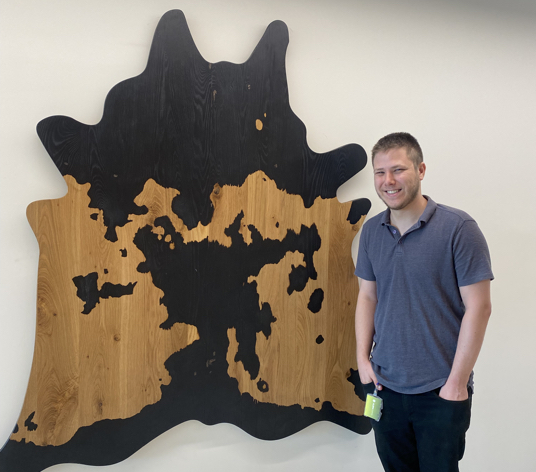 Photo of Aleph Farms' Yoav Reisler and art in the office